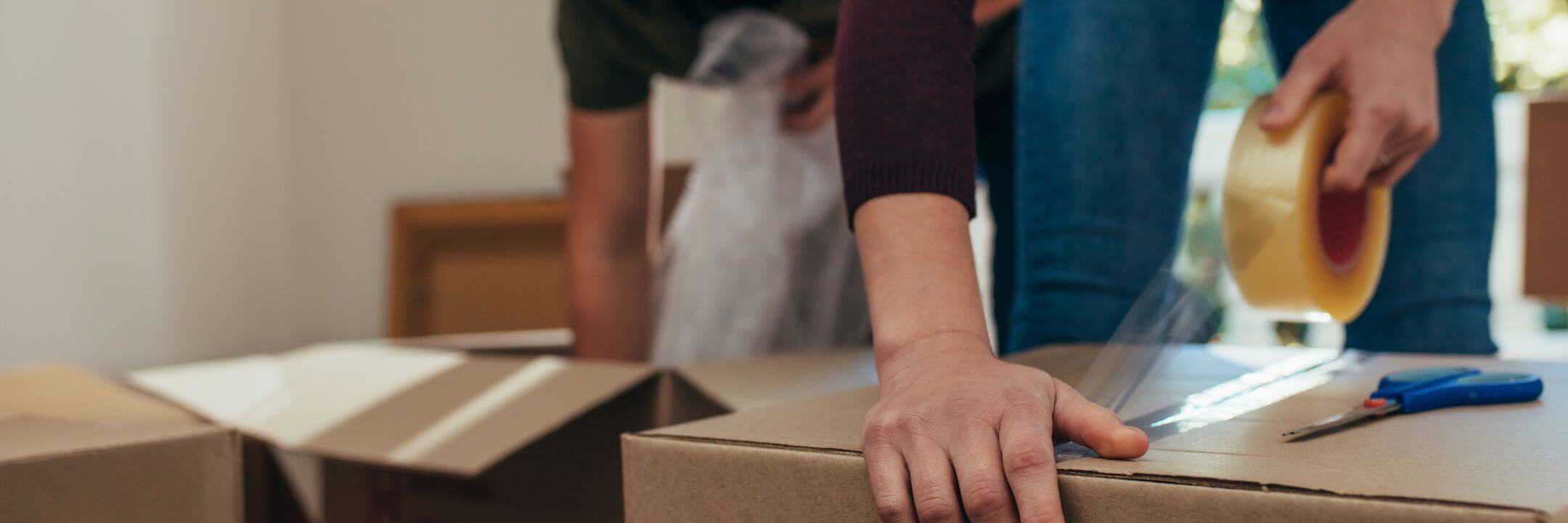 A shipping expert creating a secure, reliable seal on a package with our heavy-duty clear carton sealing tape.